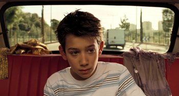 Movie still from “Mr. Bean's Holiday” (2007), directed by Steve Bendelack – A boy sitting on a seat in a car; Close Up shot, High angle