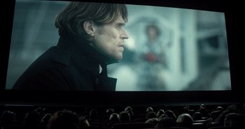 Movie still from “Mr. Bean's Holiday” (2007), directed by Steve Bendelack – People watching a movie in a theater with a man looking at the screen; Medium shot, Over the shoulder angle