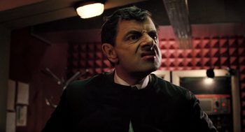 Movie still from “Mr. Bean's Holiday” (2007), directed by Steve Bendelack – A man in a black shirt is looking up at the ceiling; Close Up shot, Low angle
