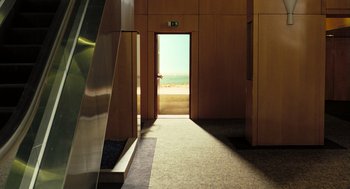Movie still from “Mr. Bean's Holiday” (2007), directed by Steve Bendelack – The door to a room is open to the beach; Extreme Wide shot, High angle
