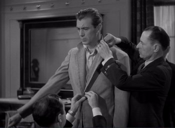 Movie still from “Mr. Deeds Goes to Town” (1936), directed by Frank Capra – A man is helping another man put on a tie; Medium shot, Over the shoulder angle