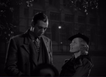Movie still from “Mr. Deeds Goes to Town” (1936), directed by Frank Capra – A man and a woman standing next to each other in front of a building; Medium shot, High angle
