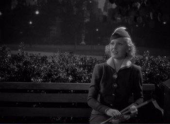 Movie still from “Mr. Deeds Goes to Town” (1936), directed by Frank Capra – An old photo of a woman holding a baseball bat in front of an audience; Medium shot, High angle