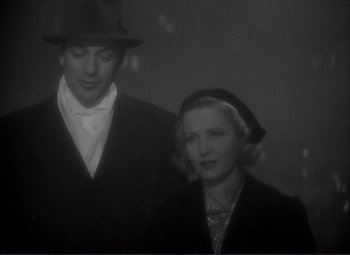 Movie still from “Mr. Deeds Goes to Town” (1936), directed by Frank Capra – A man standing next to a woman wearing a hat; Medium shot, Low angle