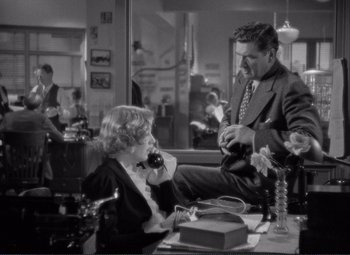 Movie still from “Mr. Deeds Goes to Town” (1936), directed by Frank Capra – A man and a woman sitting at a table; Medium shot, High angle