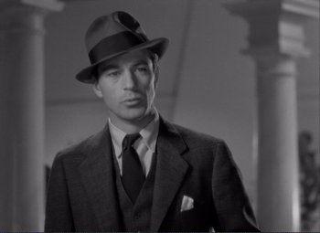Movie still from “Mr. Deeds Goes to Town” (1936), directed by Frank Capra – A black and white photo of a man wearing a suit and hat; Close Up shot, Low angle