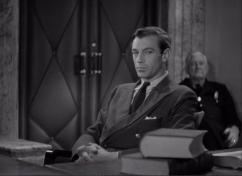 Movie still from “Mr. Deeds Goes to Town” (1936), directed by Frank Capra – A black and white photo of a man sitting at a table; Medium shot, Low angle