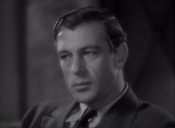 Movie still from “Mr. Deeds Goes to Town” (1936), directed by Frank Capra – An old black and white photo of a man in a suit and tie; Close Up shot, Over the shoulder angle