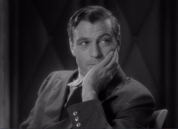 Movie still from “Mr. Deeds Goes to Town” (1936), directed by Frank Capra – A black - and - white photo of a man with his hand on his face; Close Up shot, Over the shoulder angle