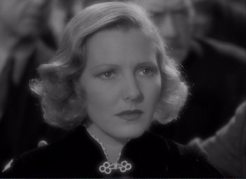 Movie still from “Mr. Deeds Goes to Town” (1936), directed by Frank Capra – An old photo of an older woman in a black dress; Close Up shot, Over the shoulder angle