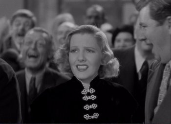 Movie still from “Mr. Deeds Goes to Town” (1936), directed by Frank Capra – An old photo of a woman in a crowd of people; Close Up shot, High angle