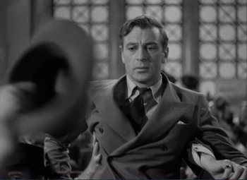 Movie still from “Mr. Deeds Goes to Town” (1936), directed by Frank Capra – A black and white photo of a man in a suit and tie; Close Up shot, Over the shoulder angle