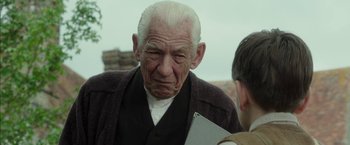Movie still from “Mr. Holmes” (2015), directed by Bill Condon – An old man with a book in his hand; Close Up shot, Over the shoulder angle
