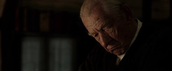 Movie still from “Mr. Holmes” (2015), directed by Bill Condon – An old man sitting in a dark room with his eyes closed; Close Up shot, Low angle
