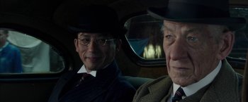 Movie still from “Mr. Holmes” (2015), directed by Bill Condon – Two men sitting in the back seat of a car; Close Up shot, Over the shoulder angle