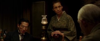 Movie still from “Mr. Holmes” (2015), directed by Bill Condon – A woman in a kimono holding a cup; Medium shot, Over the shoulder angle