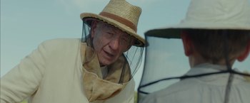 Movie still from “Mr. Holmes” (2015), directed by Bill Condon – An old man wearing a hat and a veil; Close Up shot, Over the shoulder angle