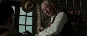 Movie still from “Mr. Holmes” (2015), directed by Bill Condon – An older man holding a glass in a room; Close Up shot, Low angle