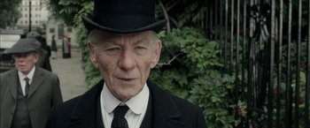 Movie still from “Mr. Holmes” (2015), directed by Bill Condon – An old man wearing a top hat and a black suit; Close Up shot, Over the shoulder angle