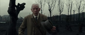 Movie still from “Mr. Holmes” (2015), directed by Bill Condon – An old man in a suit and tie holding a hat; Close Up shot, Low angle