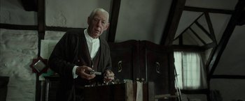 Movie still from “Mr. Holmes” (2015), directed by Bill Condon – An older man holding a pair of scissors; Medium shot, Low angle