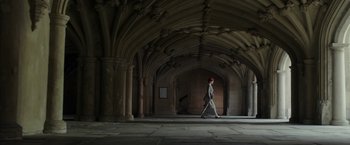 Movie still from “Mr. Holmes” (2015), directed by Bill Condon – A woman walking in a hallway with columns and arches; Extreme Wide shot, Low angle