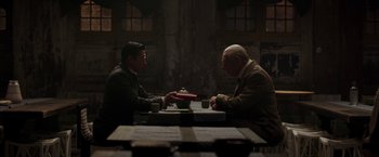 Movie still from “Mr. Holmes” (2015), directed by Bill Condon – Two men are sitting at a table and one of them is holding a plate; Medium shot, High angle