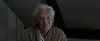 Movie still from “Mr. Holmes” (2015), directed by Bill Condon – An older man with white hair smiling for the camera; Close Up shot, Low angle