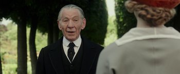 Movie still from “Mr. Holmes” (2015), directed by Bill Condon – An older man in a suit and tie looking at another man in a suit and tie; Close Up shot, Over the shoulder angle