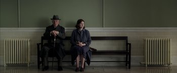 Movie still from “Mr. Holmes” (2015), directed by Bill Condon – A man and a woman sitting on a bench; Medium shot, Low angle