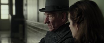 Movie still from “Mr. Holmes” (2015), directed by Bill Condon – An older man wearing a hat and a suit; Close Up shot, Over the shoulder angle