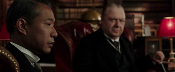 Movie still from “Mr. Holmes” (2015), directed by Bill Condon – A man in a suit and tie sitting next to another man in a suit and tie; Close Up shot, Over the shoulder angle