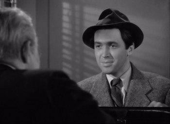 Movie still from “Mr. Smith Goes to Washington” (1939), directed by Frank Capra – A black and white photo of a man in a suit and a hat; Close Up shot, Over the shoulder angle