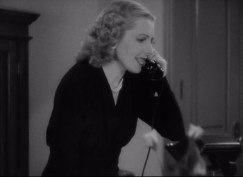Movie still from “Mr. Smith Goes to Washington” (1939), directed by Frank Capra – A woman talking on a phone while standing in a room; Close Up shot, High angle