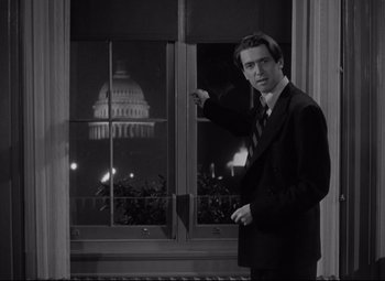 Movie still from “Mr. Smith Goes to Washington” (1939), directed by Frank Capra – A black and white photo of a man in front of a window; Medium shot, Low angle