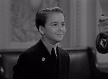 Movie still from “Mr. Smith Goes to Washington” (1939), directed by Frank Capra – A young boy in a suit and tie looking to his left; Close Up shot, Low angle