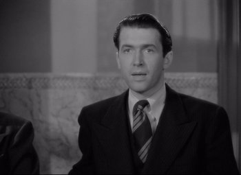 Movie still from “Mr. Smith Goes to Washington” (1939), directed by Frank Capra – A black and white photo of a man in a suit and tie; Close Up shot, High angle