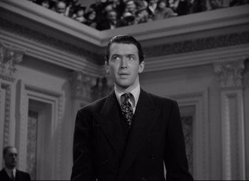 Movie still from “Mr. Smith Goes to Washington” (1939), directed by Frank Capra – A man wearing a suit and tie in a room; Medium shot, Low angle