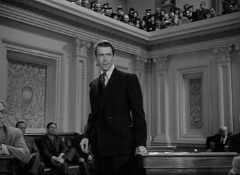 Movie still from “Mr. Smith Goes to Washington” (1939), directed by Frank Capra – A black and white photo of a man in a courtroom; Medium shot, Low angle