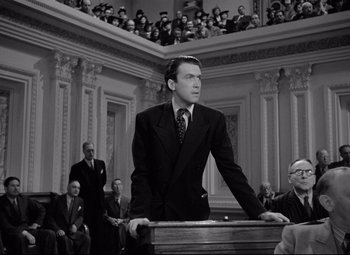 Movie still from “Mr. Smith Goes to Washington” (1939), directed by Frank Capra – A black and white photo of a man in a suit and tie; Medium shot, Low angle