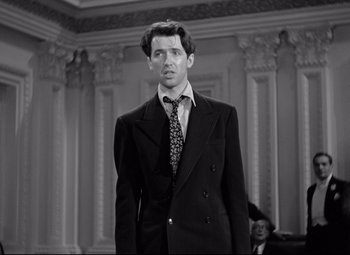 Movie still from “Mr. Smith Goes to Washington” (1939), directed by Frank Capra – A man in a suit and tie standing in front of a wall; Medium shot, Low angle