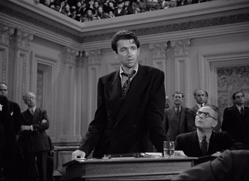 Movie still from “Mr. Smith Goes to Washington” (1939), directed by Frank Capra – A black and white photo of a man in a courtroom; Medium shot, Low angle