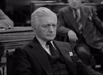 Movie still from “Mr. Smith Goes to Washington” (1939), directed by Frank Capra – An older man in a suit sitting in a chair; Medium shot, High angle