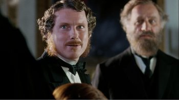 Movie still from “Mrs. Brown” (1997), directed by John Madden – A man in a suit and a bow tie looking at the camera; Close Up shot, Over the shoulder angle