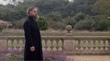 Movie still from “Mrs. Brown” (1997), directed by John Madden – A man in a long black coat standing in a garden; Medium shot, Over the shoulder angle