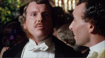 Movie still from “Mrs. Brown” (1997), directed by John Madden – A man in a suit and bow tie looking at another man in a suit and bow tie in front of a crowd; Close Up shot, Over the shoulder angle