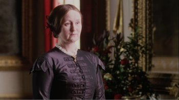 Movie still from “Mrs. Brown” (1997), directed by John Madden – A woman in a black dress standing in front of a christmas tree; Medium shot, Low angle
