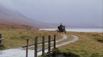 Movie still from “Mrs. Brown” (1997), directed by John Madden – A man riding a horse drawn carriage down a road near a lake; Extreme Wide shot, Low angle