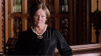 Movie still from “Mrs. Brown” (1997), directed by John Madden – An older woman wearing a black dress and a gold necklace; Close Up shot, Low angle