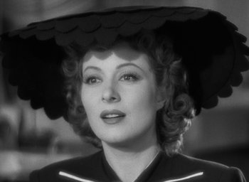 Movie still from “Mrs. Miniver” (1942), directed by William Wyler – A black and white photo of a woman wearing a hat; Close Up shot, Low angle